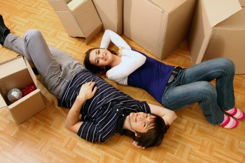 Mover wearing PPE while lifting boxes during a house removal